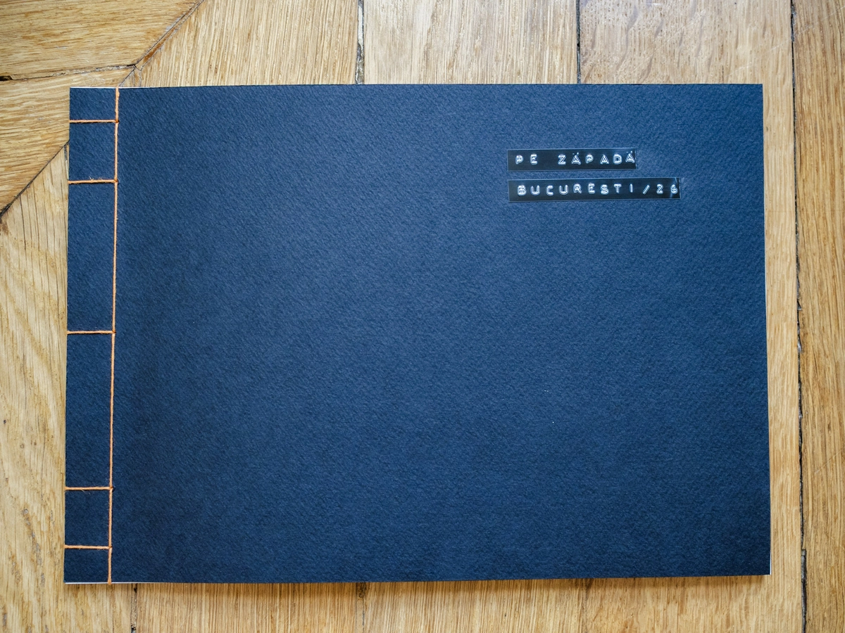 Dark blue handmade photo book cover labeled Pe Zăpadă, București