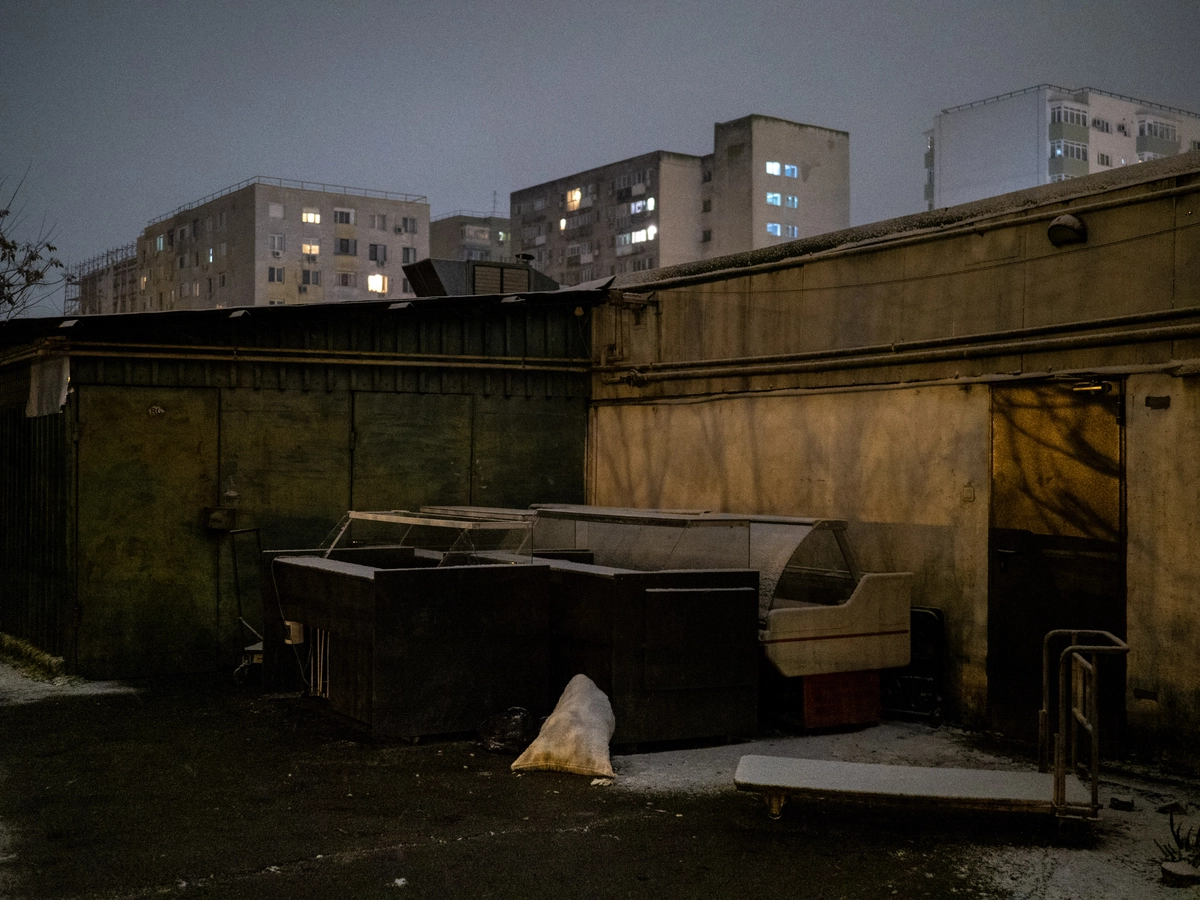 Dimly lit courtyard with discarded furniture behind apartment blocks